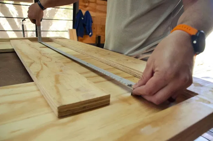 Manos midiendo con precisión tablones de madera